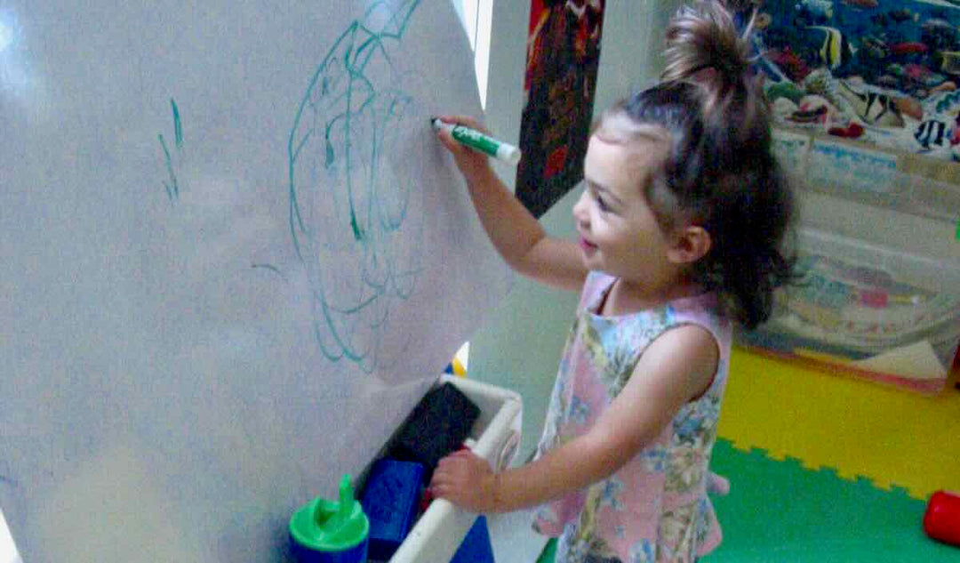 Toddler writes on white board 